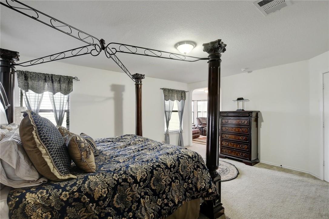 356 Matthews Kyle, TX 78640 - Photo 10 of 30 A spacious bedroom features a distinctive four-poster bed and plush carpet flooring.