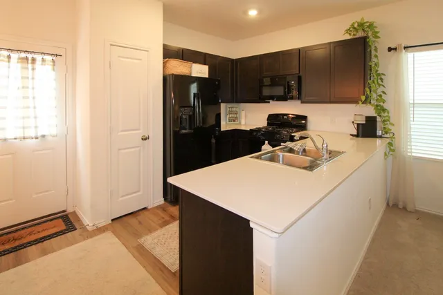 a kitchen with kitchen island granite countertop a refrigerator stove and sink