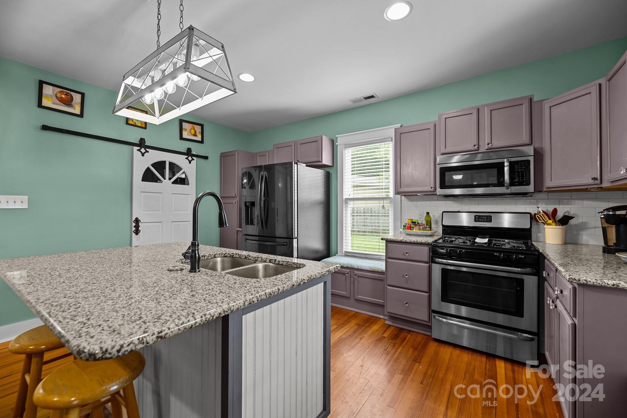 284 8th Avenue Cramerton, NC 28032 - Photo 9 of 29 a kitchen with stainless steel appliances granite countertop a sink dishwasher stove and microwave with wooden floor