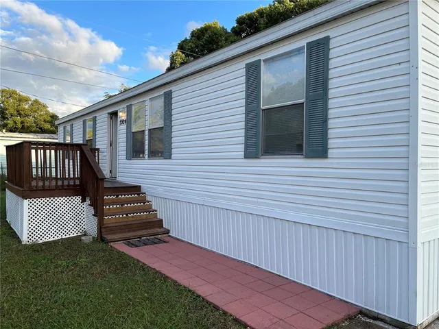 a view of a house with wooden deck and a backyard