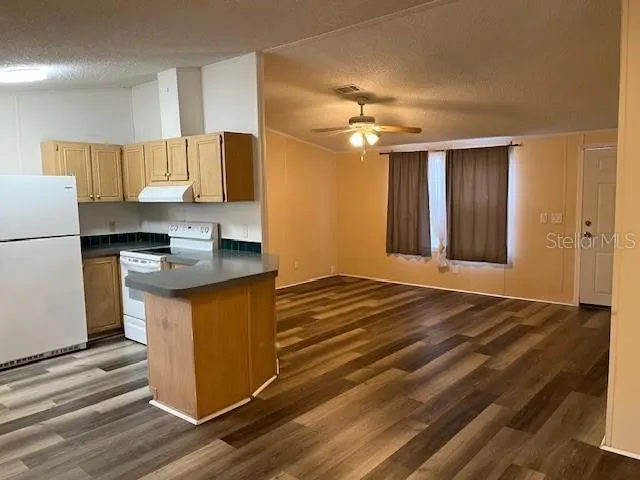 a kitchen with kitchen island granite countertop a sink appliances cabinets and counter space