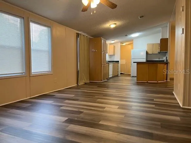 a view of a livingroom with kitchen appliances and furniture