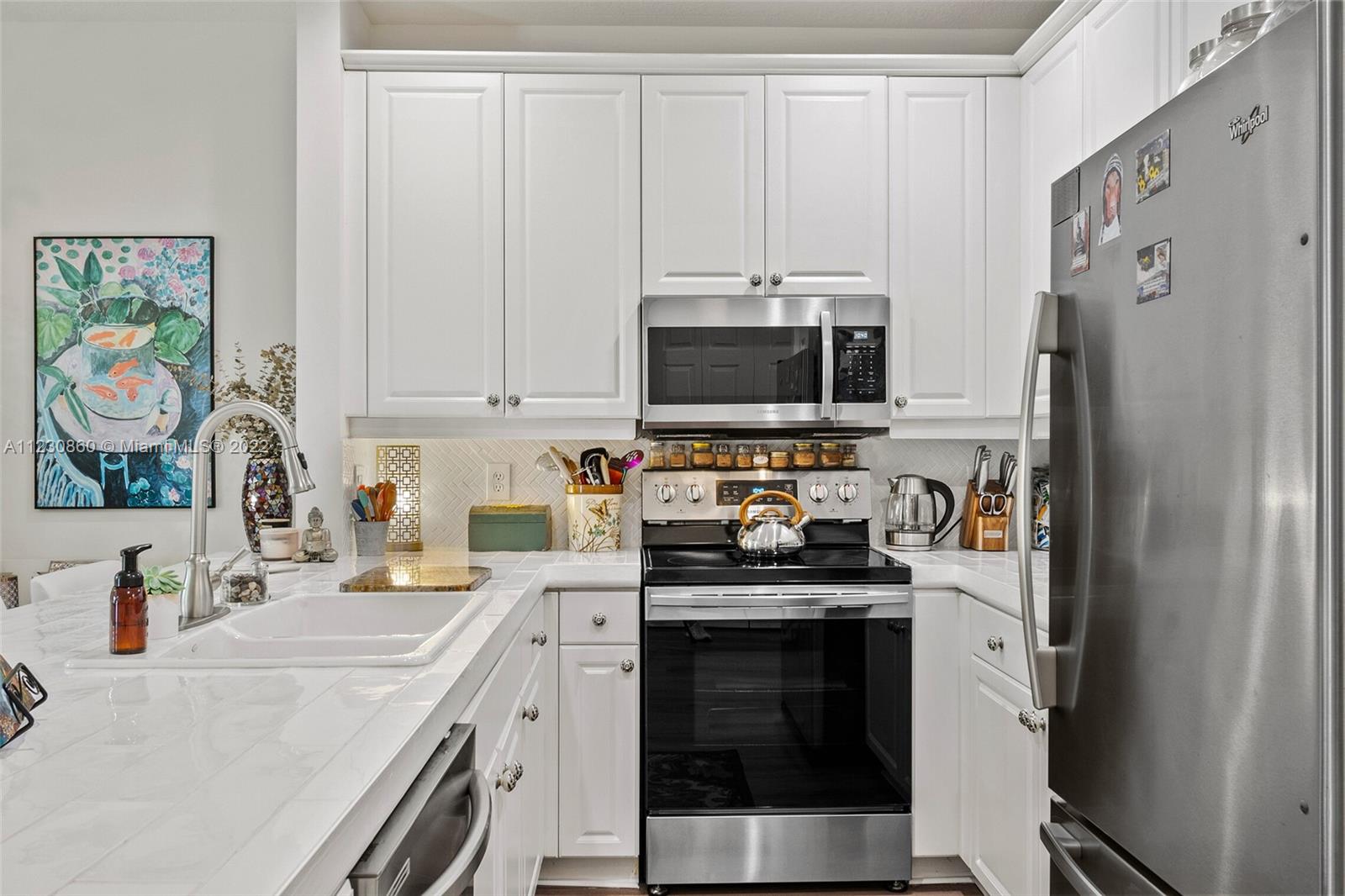 4332 Main Street Jupiter, FL 33458 - Photo 11 of 28 a kitchen with stainless steel appliances a stove microwave and refrigerator