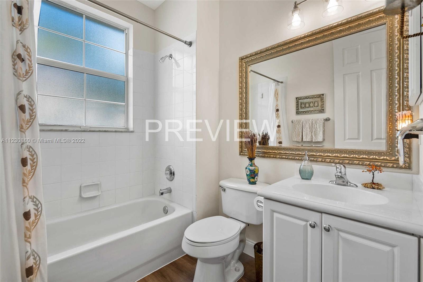 4332 Main Street Jupiter, FL 33458 - Photo 14 of 28 a bathroom with a granite countertop toilet a sink and a bathtub