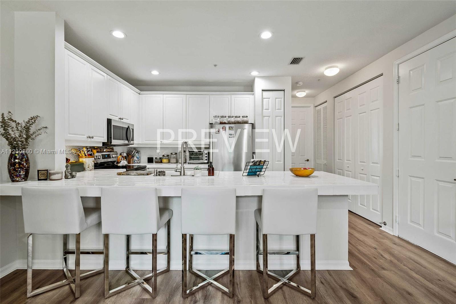 4332 Main Street Jupiter, FL 33458 - Photo 10 of 28 a kitchen with stainless steel appliances a white table chairs refrigerator and sink