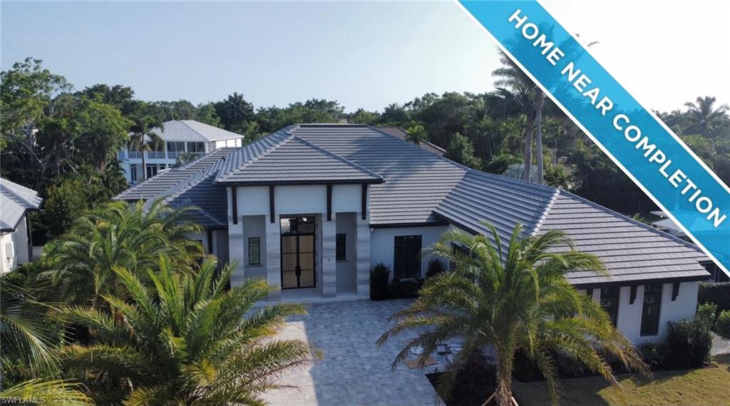 560 Rudder Road Naples, FL 34102 - Photo 2 of 23 a front view of a house with a yard