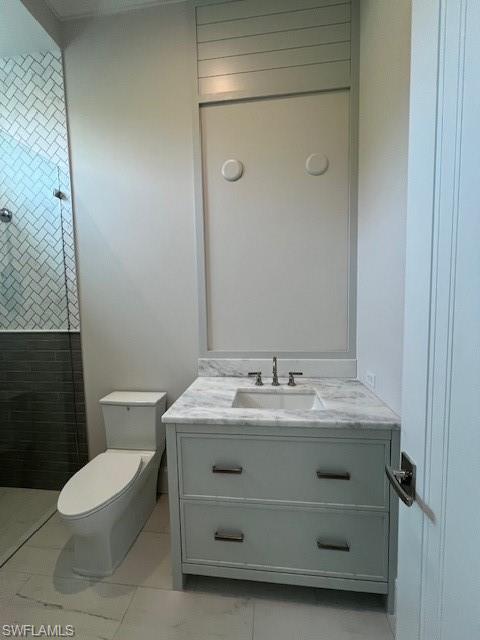 560 Rudder Road Naples, FL 34102 - Photo 21 of 23 a bathroom with a granite countertop sink a toilet and a mirror