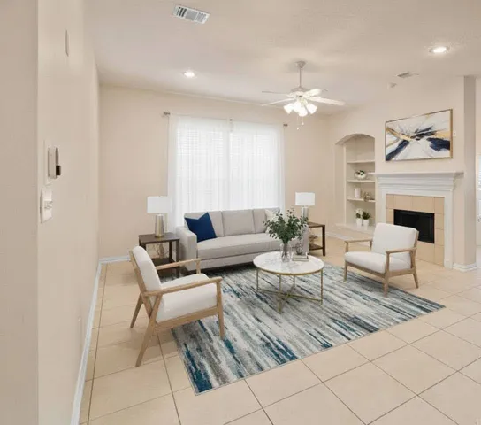 a living room with furniture a fireplace and a chandelier