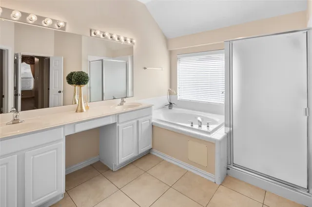 a bathroom with a double vanity sink a mirror and a bathtub