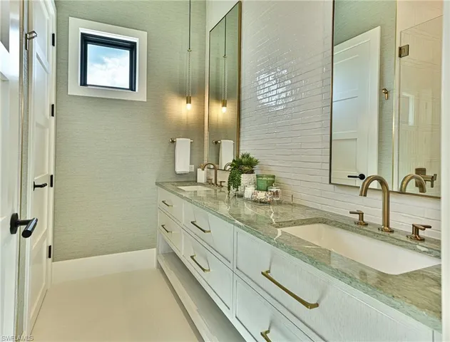 a bathroom with a granite countertop sink a mirror and a shower