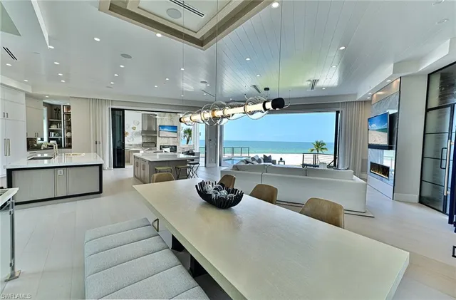 a large kitchen with stainless steel appliances a large counter top a stove and a sink