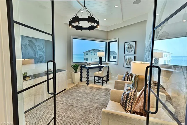 a living room with furniture a chandelier and a large window