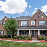 a front view of a house with a yard and potted plants