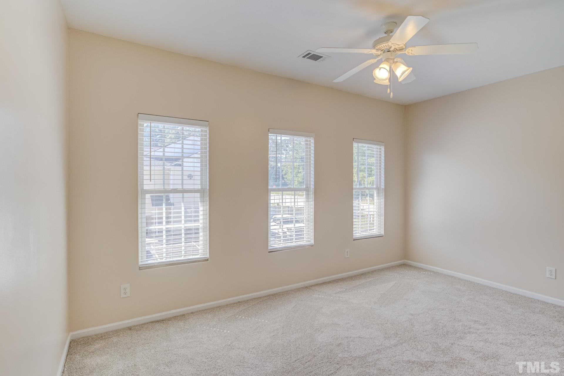 705 Glen Road, Unit 103 Garner, NC 27529 - Photo 17 of 25 an empty room with windows and fan