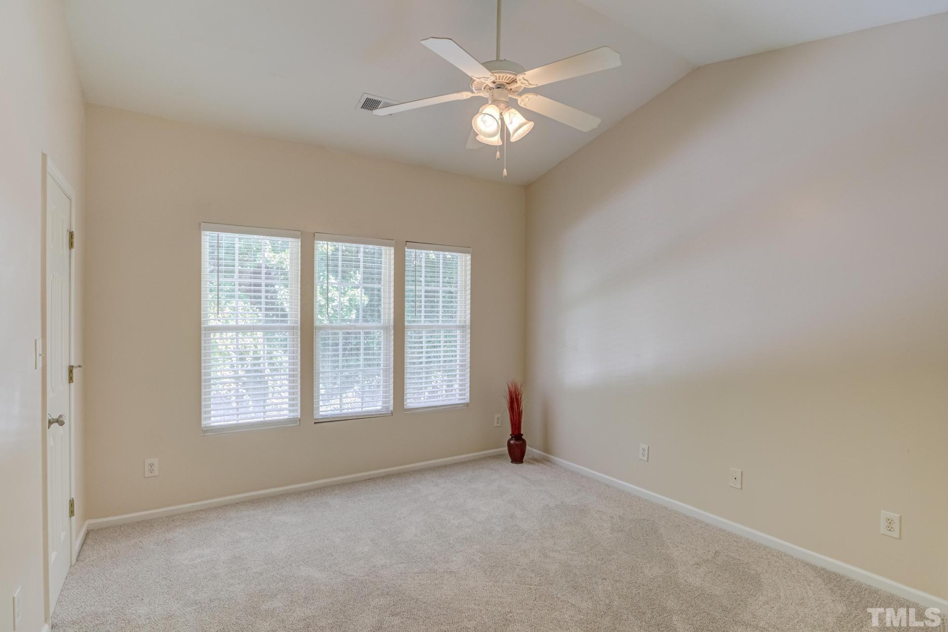 705 Glen Road, Unit 103 Garner, NC 27529 - Photo 20 of 25 an empty room with chandelier fan and windows