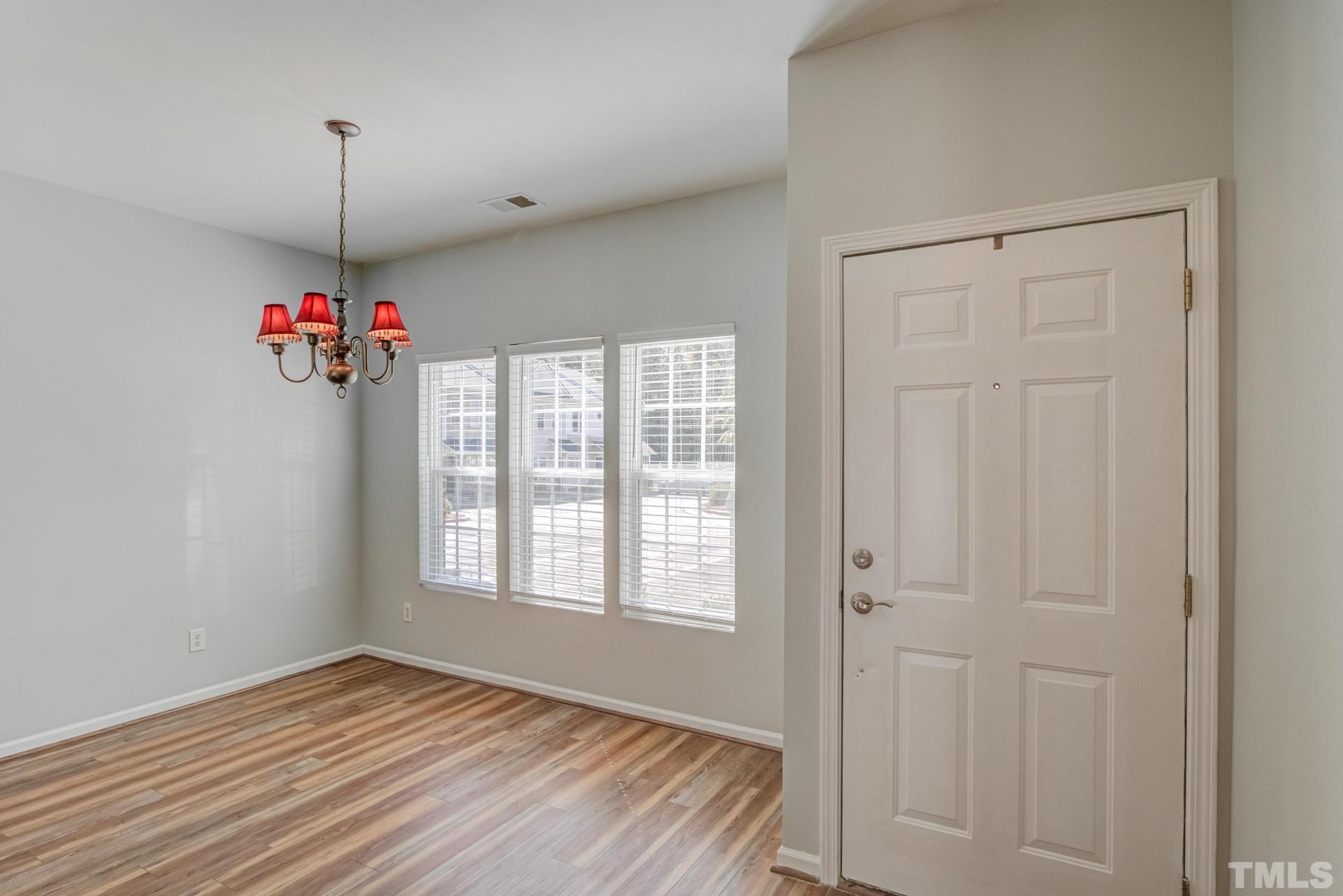 705 Glen Road, Unit 103 Garner, NC 27529 - Photo 5 of 25 a view of an empty room with window and wooden floor