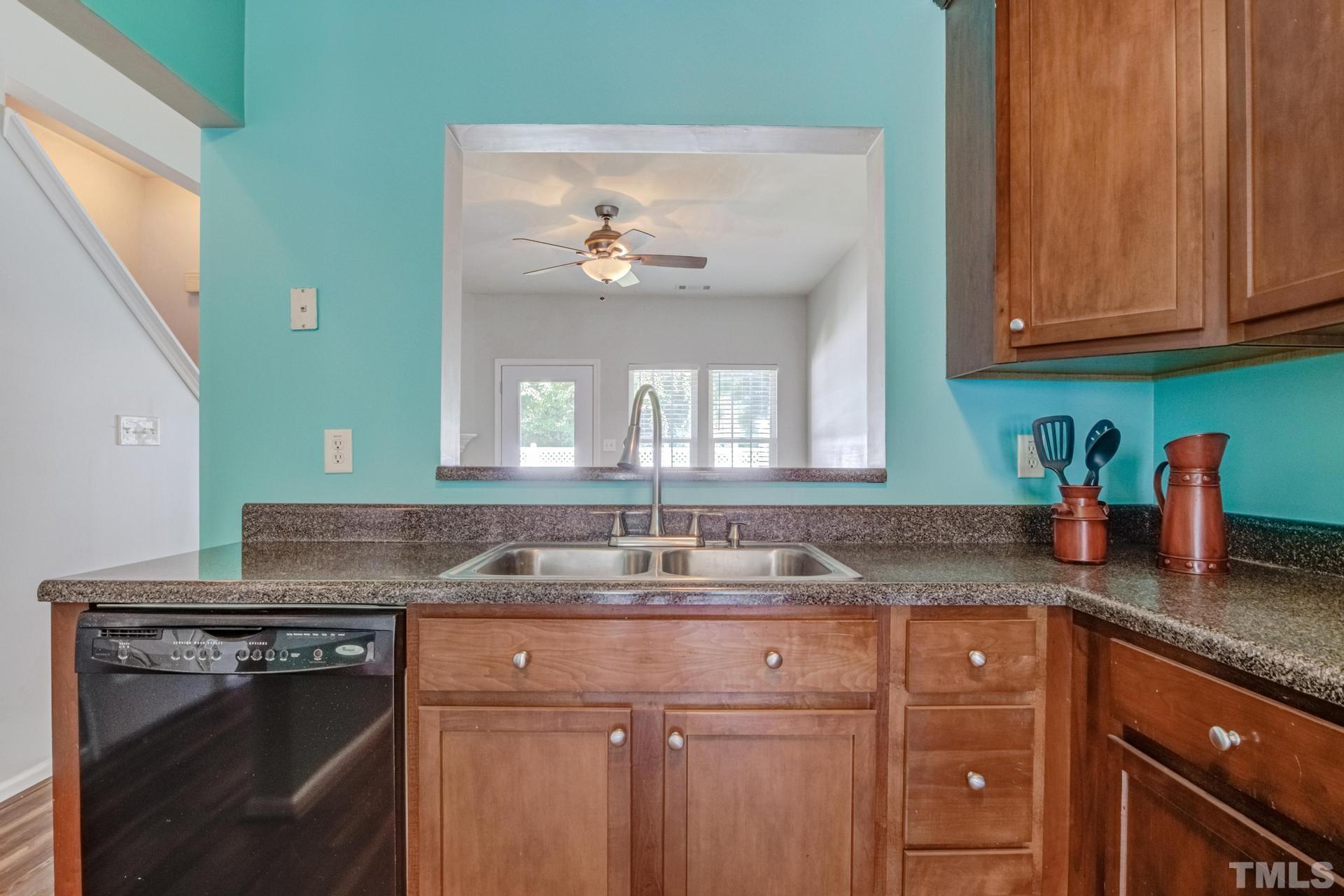 705 Glen Road, Unit 103 Garner, NC 27529 - Photo 10 of 25 a kitchen with granite countertop a sink stainless steel appliances white cabinets and a window