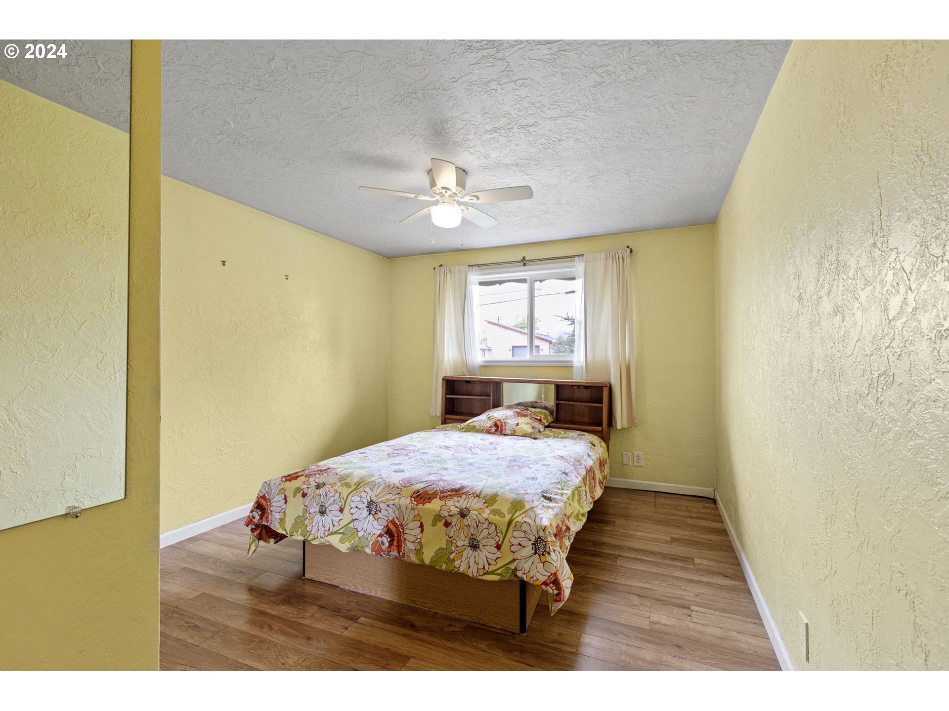 2484 19th Street Springfield, OR 97477 - Photo 18 of 30 a bedroom with a bed and a chandelier