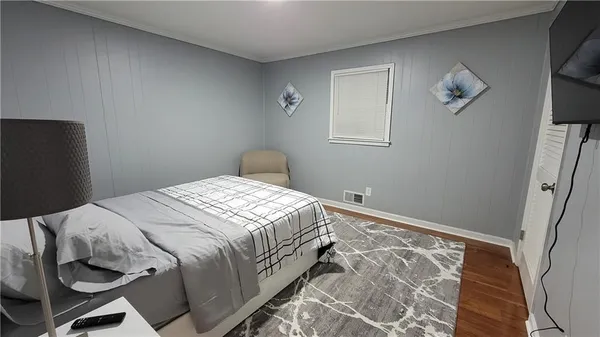 a bedroom with a bed and wooden floor