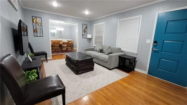 a living room with furniture rug and wooden floor