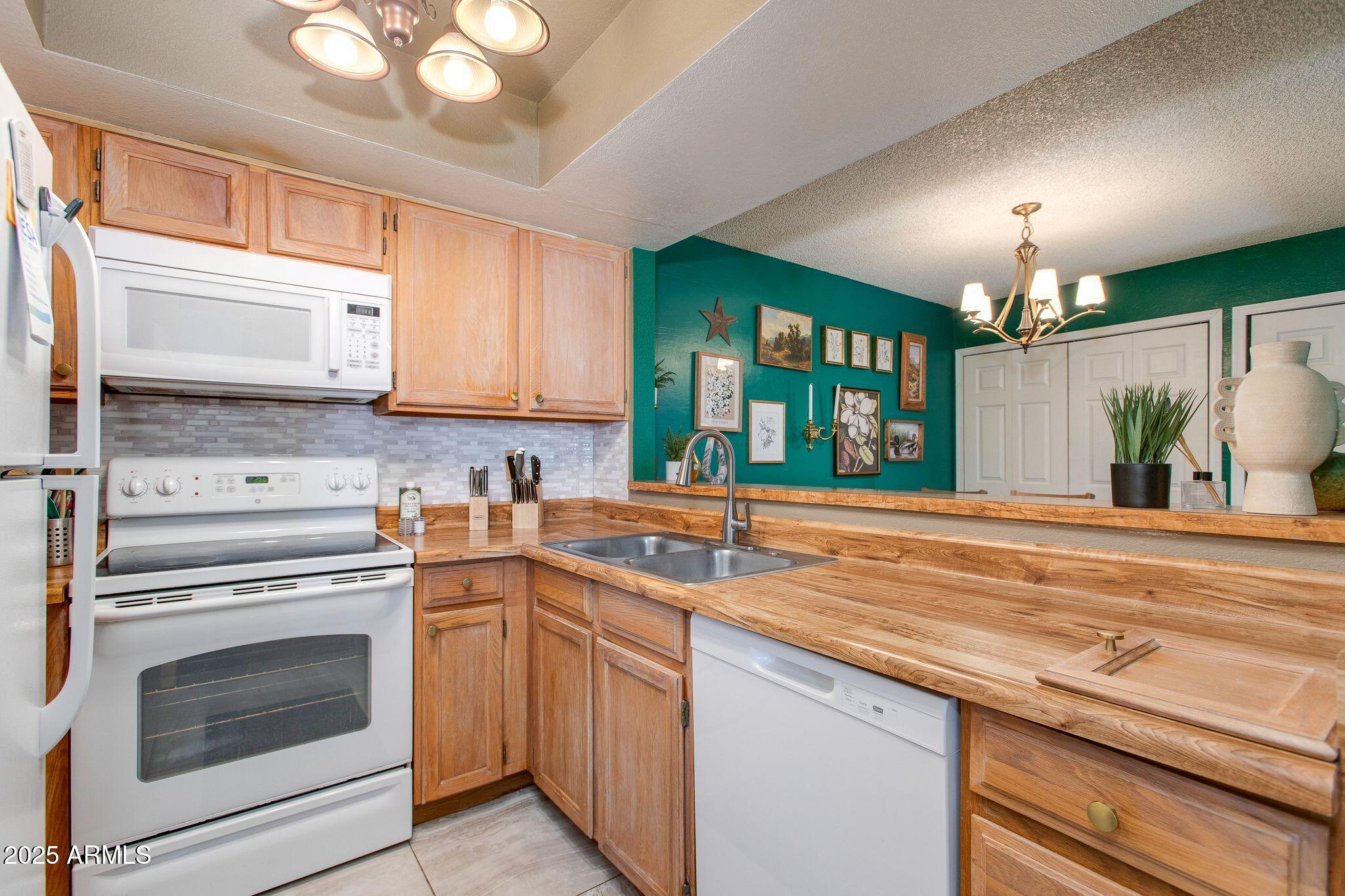 1645 West Baseline Road, Unit 1058 Mesa, AZ 85202 - Photo 28 of 44 a kitchen with granite countertop a sink stainless steel appliances and cabinets