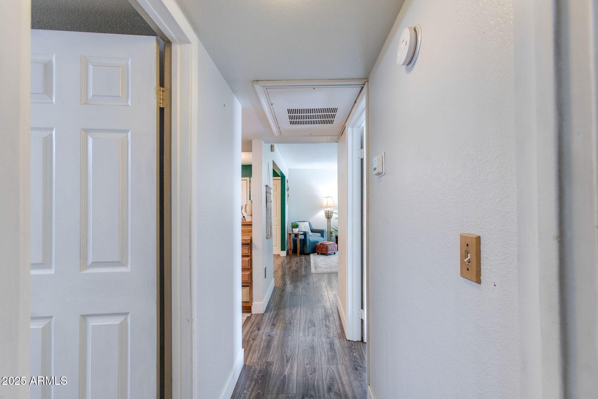 1645 West Baseline Road, Unit 1058 Mesa, AZ 85202 - Photo 30 of 44 a view of a hallway with wooden floor
