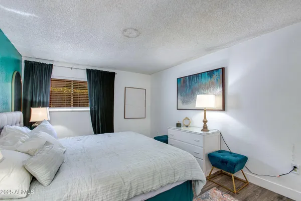 a bedroom with a bed and a painting on the wall