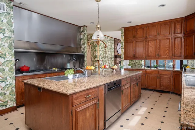 a kitchen with stainless steel appliances granite countertop a sink a stove and a wooden floors