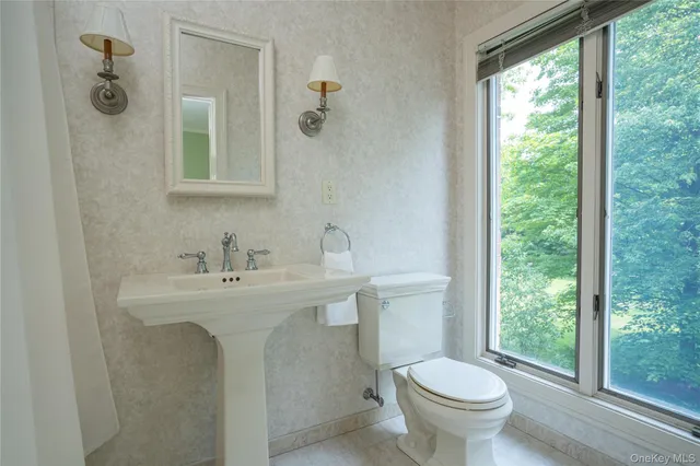 a bathroom with a toilet sink and mirror