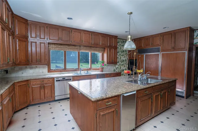 a kitchen with stainless steel appliances granite countertop a sink and a refrigerator