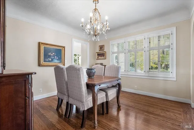 a view of a dining room with furniture a chandelier and wooden floor