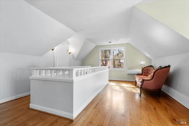 a view of a hallway with furniture and wooden floor