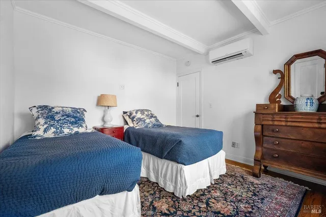 a bedroom with two beds and painting on the wall