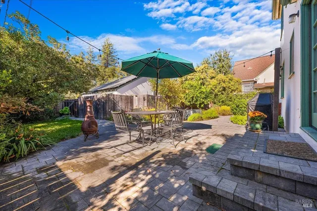 a view of a patio with a table and chairs under an umbrella