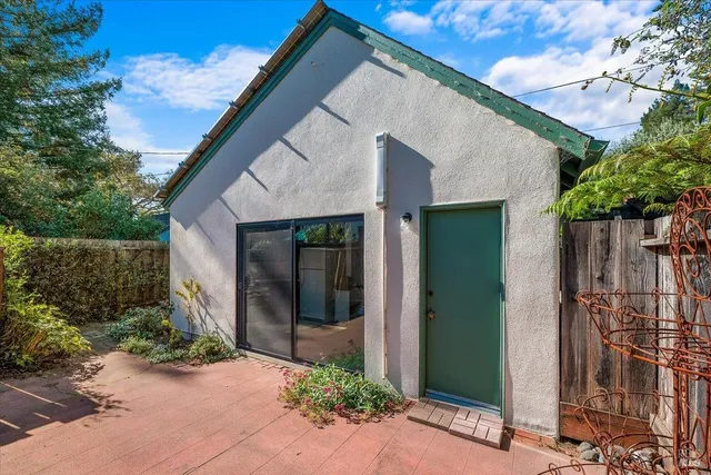 a view of a white house with a small garden