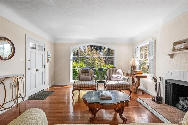 a living room with furniture a fireplace and a floor to ceiling window