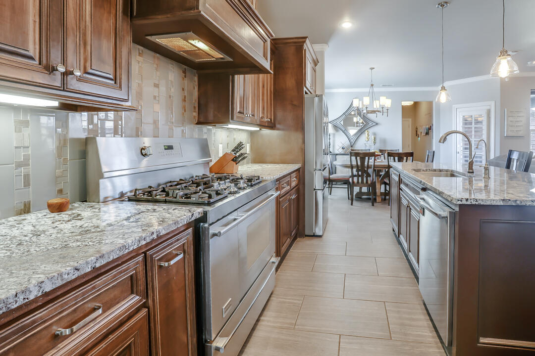4712 121st Street Lubbock, TX 79424 - Photo 11 of 46 a kitchen with stainless steel appliances granite countertop a stove a sink and a microwave