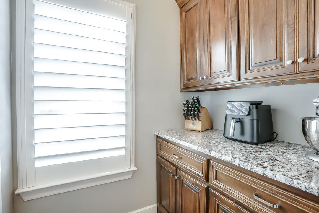 4712 121st Street Lubbock, TX 79424 - Photo 12 of 46 a kitchen with granite countertop a sink and a white wooden cabinets