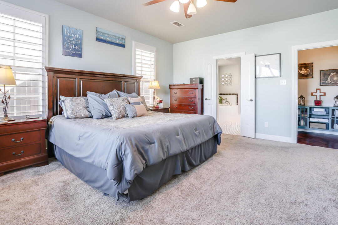 4712 121st Street Lubbock, TX 79424 - Photo 15 of 46 a bedroom with a bed and a chandelier