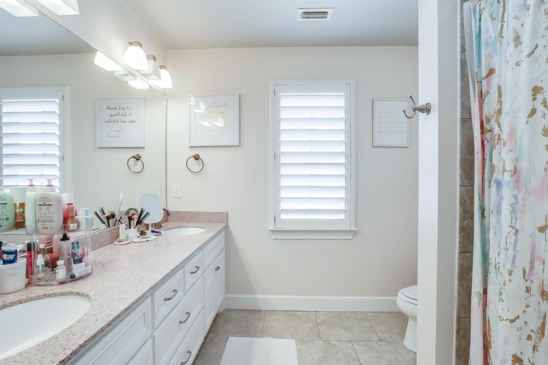 4712 121st Street Lubbock, TX 79424 - Photo 23 of 46 a bathroom with a double vanity sink toilet and shower