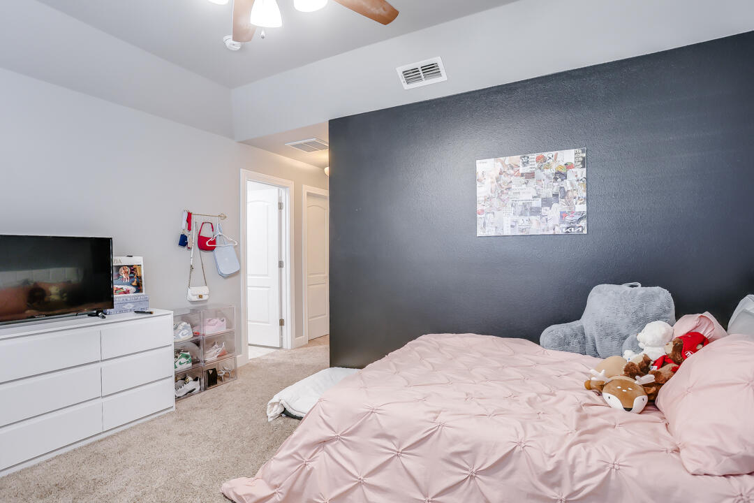4712 121st Street Lubbock, TX 79424 - Photo 26 of 46 a bedroom with a bed and flat screen tv