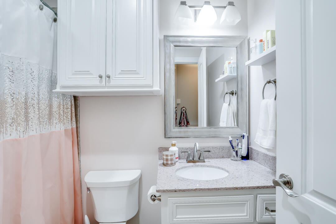 4712 121st Street Lubbock, TX 79424 - Photo 27 of 46 a bathroom with a granite countertop toilet sink and mirror