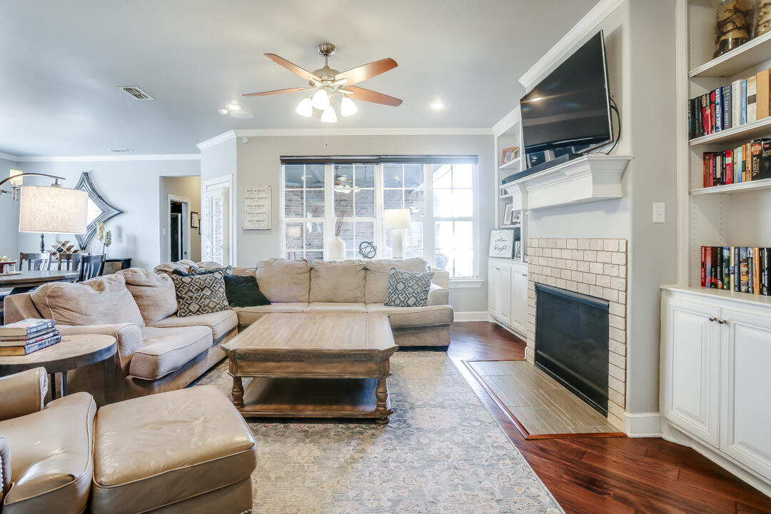 4712 121st Street Lubbock, TX 79424 - Photo 5 of 46 a living room with furniture a flat screen tv and a fireplace