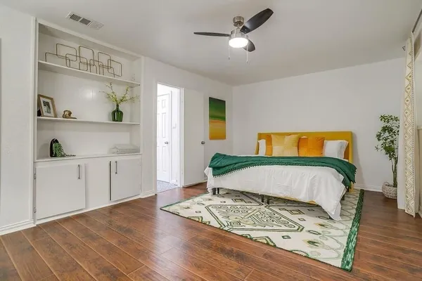a bedroom with a bed and wooden floor
