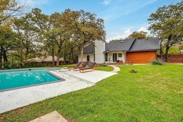 a swimming pool with outdoor seating and yard