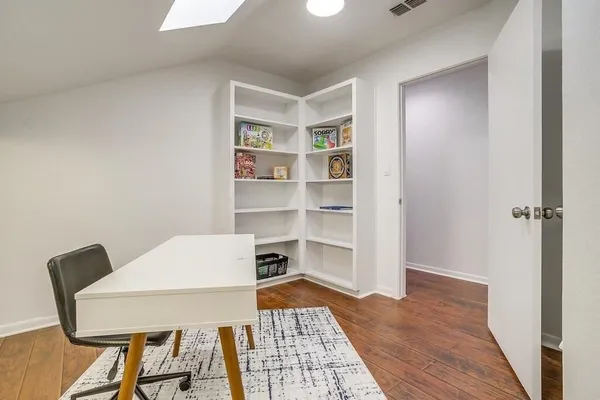 a view of a workspace with furniture and wooden floor