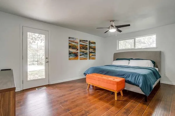 a bedroom with a bed and wooden floor