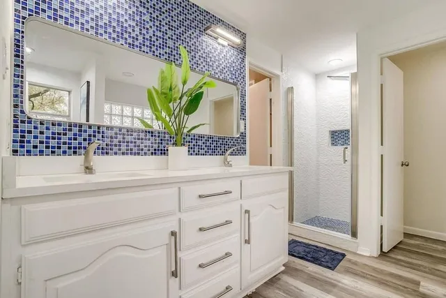 a bathroom with a sink a mirror and a shower