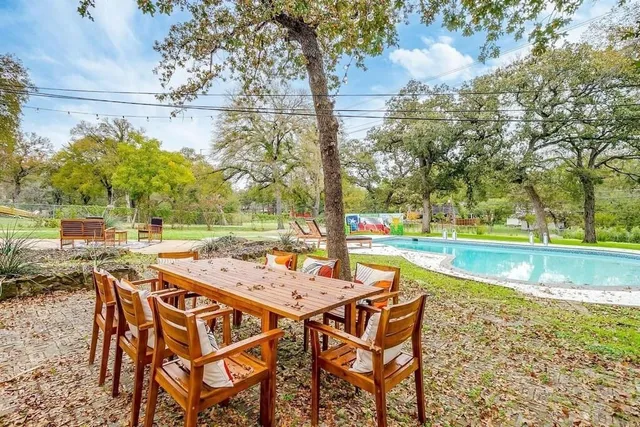 a patio with glass top table and chairs