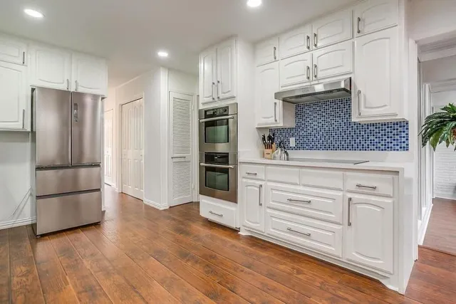 a kitchen with stainless steel appliances a refrigerator and a stove top oven